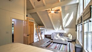 A bedroom with a bed, a ceiling fan, a window with curtains, and a small heater. - Gilford Cabin - 2 Mi to Gunstock Mountain Resort! (Gilford)