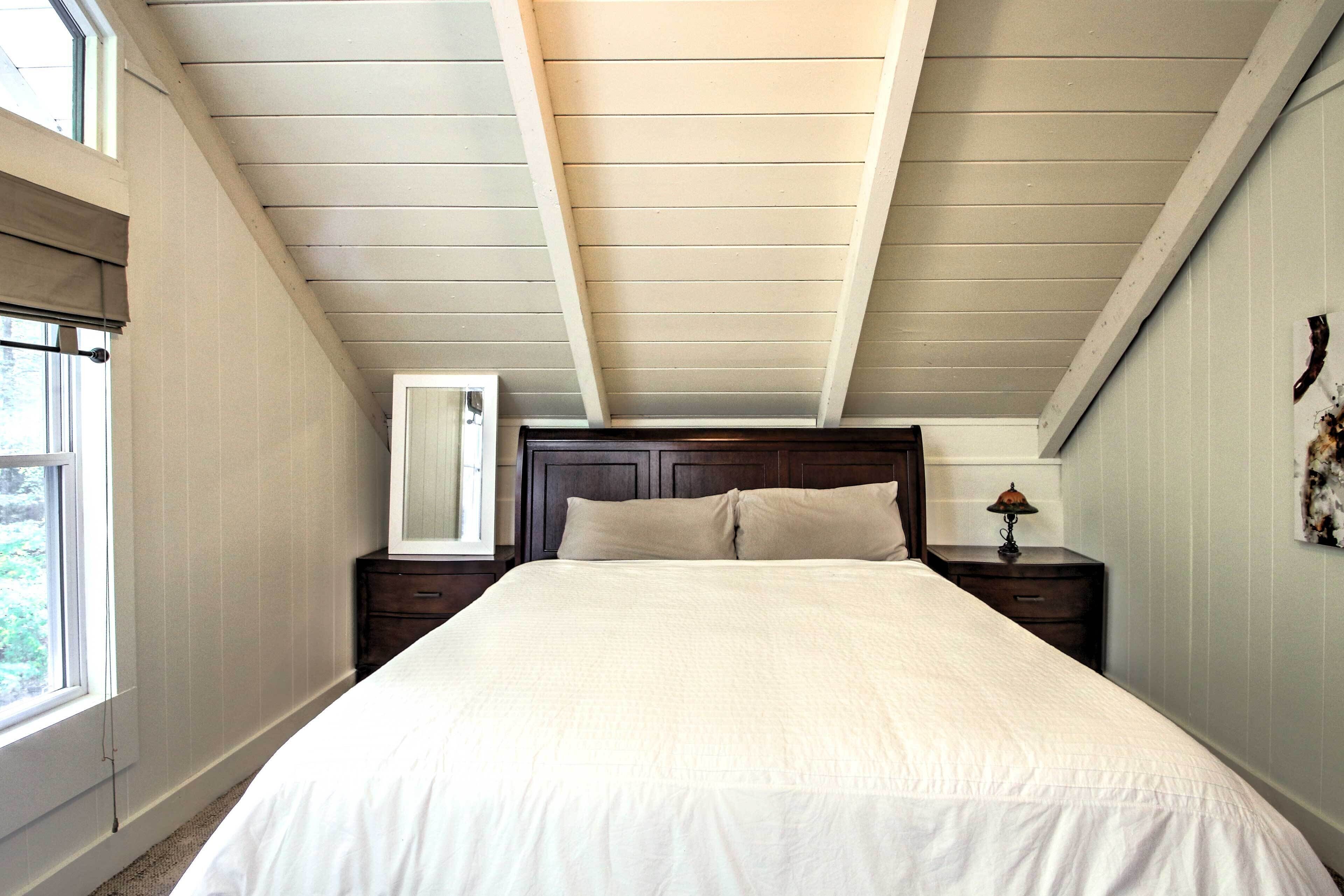 Un dormitorio con una cama grande, cabecera de madera y una mesita de noche con lámpara.