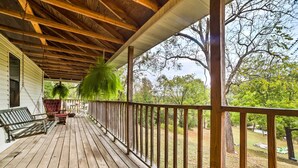 A wooden deck with a railing, a bench, and a hanging plant. - Historic Bruno 'hampton Creek Hideaway' on 2 Acres (Everton)