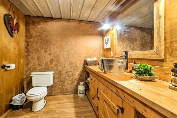 Une salle de bain en bois avec des toilettes, un lavabo et un miroir.