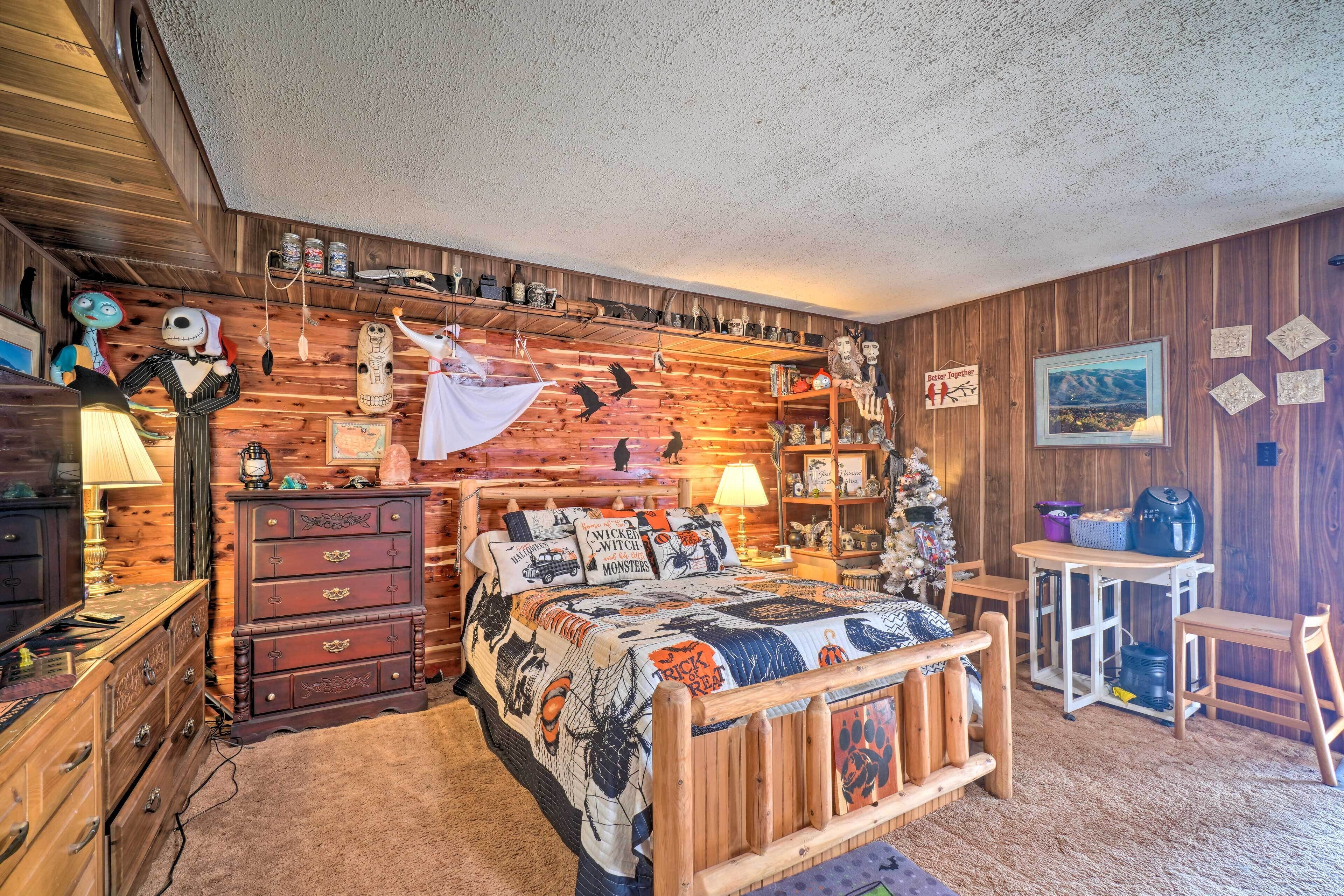 A rustic bedroom with a wooden headboard, a quilted bedspread, and a shelf with various items.