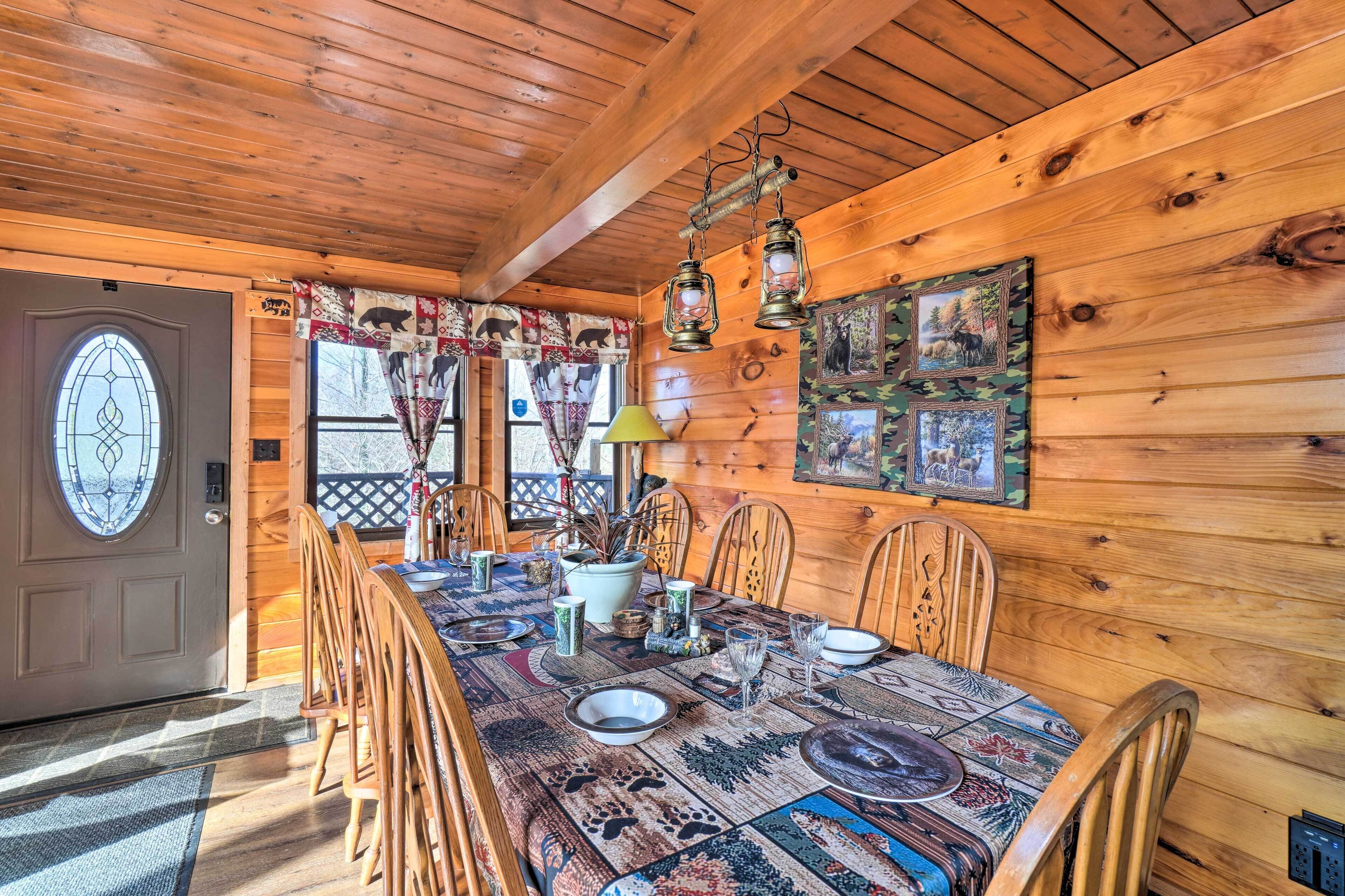 A wooden dining room with a large table set for four, surrounded by wooden chairs.