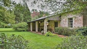 A rustic house with a covered porch, brick walls, and a well-maintained lawn. - Historic Baton Rouge Vacation Rental: 6 Mi to Lsu! (Baton Rouge)