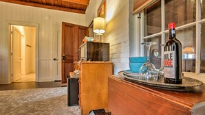 A wooden dresser with a bottle of wine and glasses on top. - Historic Baton Rouge Vacation Rental: 6 Mi to Lsu! (Baton Rouge)