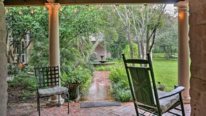 A covered patio with two chairs, a brick pathway, and a fountain. - Historic Baton Rouge Vacation Rental: 6 Mi to Lsu! (Baton Rouge)