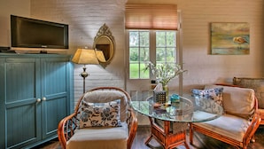 A room with a television, wicker chairs, a glass table, and a window with blinds. - Historic Baton Rouge Vacation Rental: 6 Mi to Lsu! (Baton Rouge)