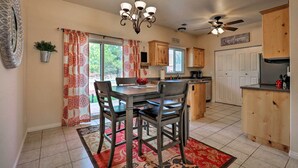 A kitchen with a dining table, chairs, a chandelier, wooden cabinets, and a ceiling fan. - Kanab Condo w/ Pool & Patio, 30 Mi to Zion NP (Kanab)