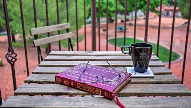 A wooden table with a book, a pair of glasses, and a mug on a balcony. - Kanab Condo w/ Pool & Patio, 30 Mi to Zion NP (Kanab)
