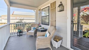 A covered porch with wicker chairs, a small table, and a potted plant. - Mississippi Cottage ~ 6 Mi to Columbus Lake (Columbus)