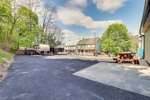 A campground with RVs, a picnic table, and houses in the background.
