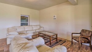A living room with a beige sofa, a glass-top coffee table, a patterned rug, and a wooden floor. - Mtn Gem w/ Breathtaking Scenery: 7 Mi to Dtwn (Del Norte)