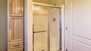A bathroom with a glass shower enclosure, a wooden cabinet, and a white door. - Mtn Gem w/ Breathtaking Scenery: 7 Mi to Dtwn (Del Norte)