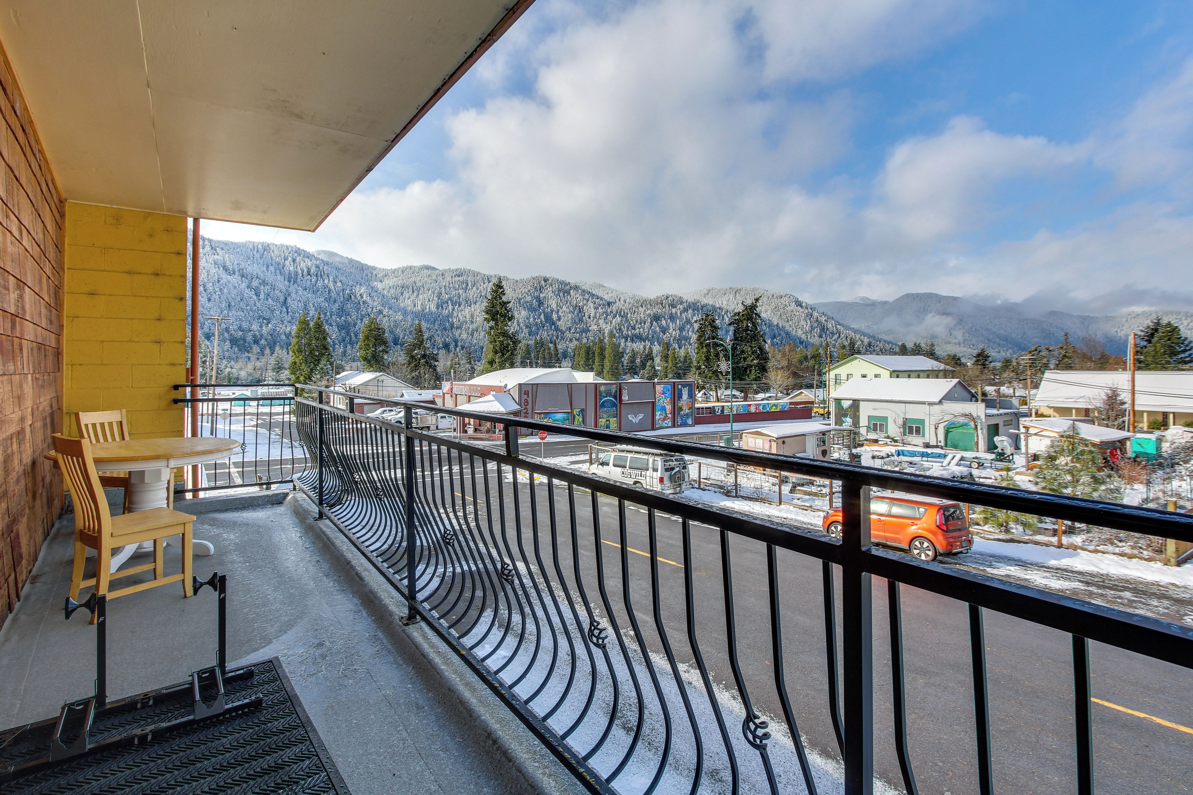 A balcony with a view of a town and mountains.