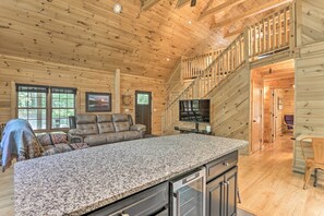 A spacious living room with a large granite countertop, leather sofa, and a television. - Palmerton Cabin w/ Game Room ~ 5 Mi to Blue Mtn (Palmerton)