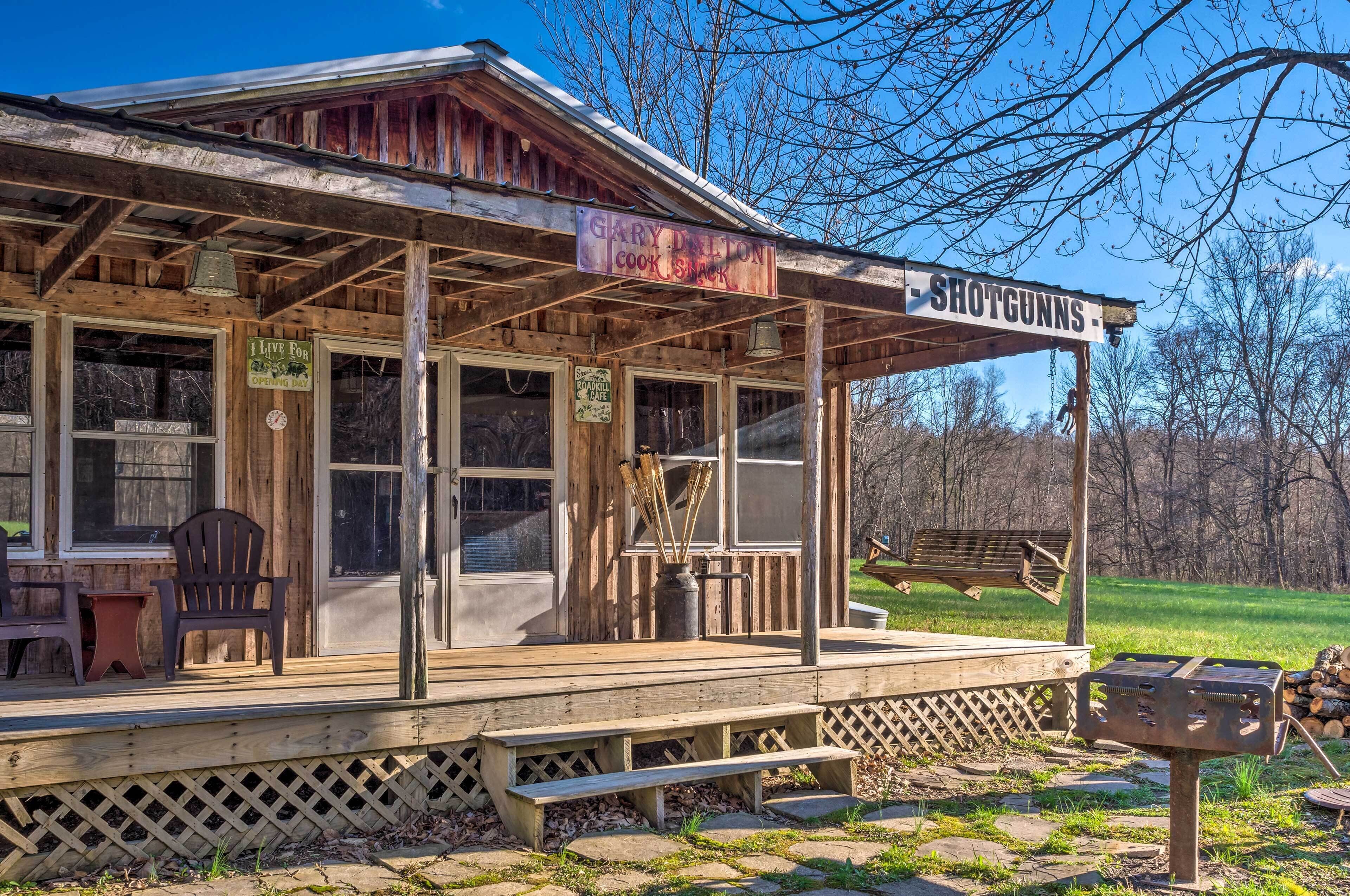 Un bâtiment rustique en bois, doté d’un porche, d’une enseigne indiquant « Garry Dixon Cook Shack » et d’une autre enseigne pour « Shotguns ».