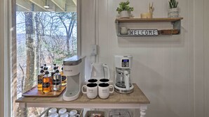 A kitchen counter with a coffee maker, mugs, and bottles of syrup. - Rustic Beech Mtn Cabin < 1 Mi to Ski Resort! (Banner Elk)