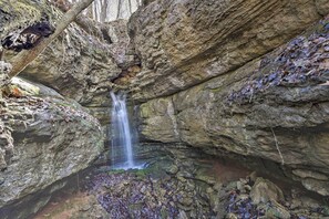 A natural rock formation with a waterfall. - Secluded Getaway Home w/ Trails + Waterfall! (Falkville)