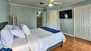 A bedroom with a bed, a ceiling fan, a TV mounted on the wall, and a door. - Pet-friendly Lafayette Vacation Rental! (Lafayette)