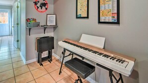 A piano in a hallway with a map and a framed certificate on the wall. - Pet-friendly Lafayette Vacation Rental! (Lafayette)