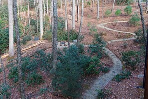 A forested area with a winding path, a small clearing with a bench, and a stone structure. - Secluded Sapphire Chalet w/ Game Room + Decks (Sapphire)