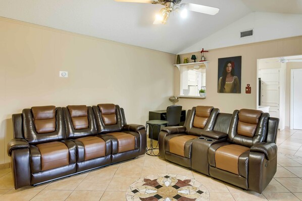 A living room with two reclining sofas, a small round table, and a decorative rug. - San Antonio Home: Near Nature, Parks & Trails (San Antonio)