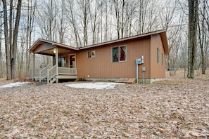 A cabin with a porch, a staircase, and a small deck.