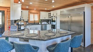 A modern kitchen with granite countertops, stainless steel appliances, and a central island with bar seating.