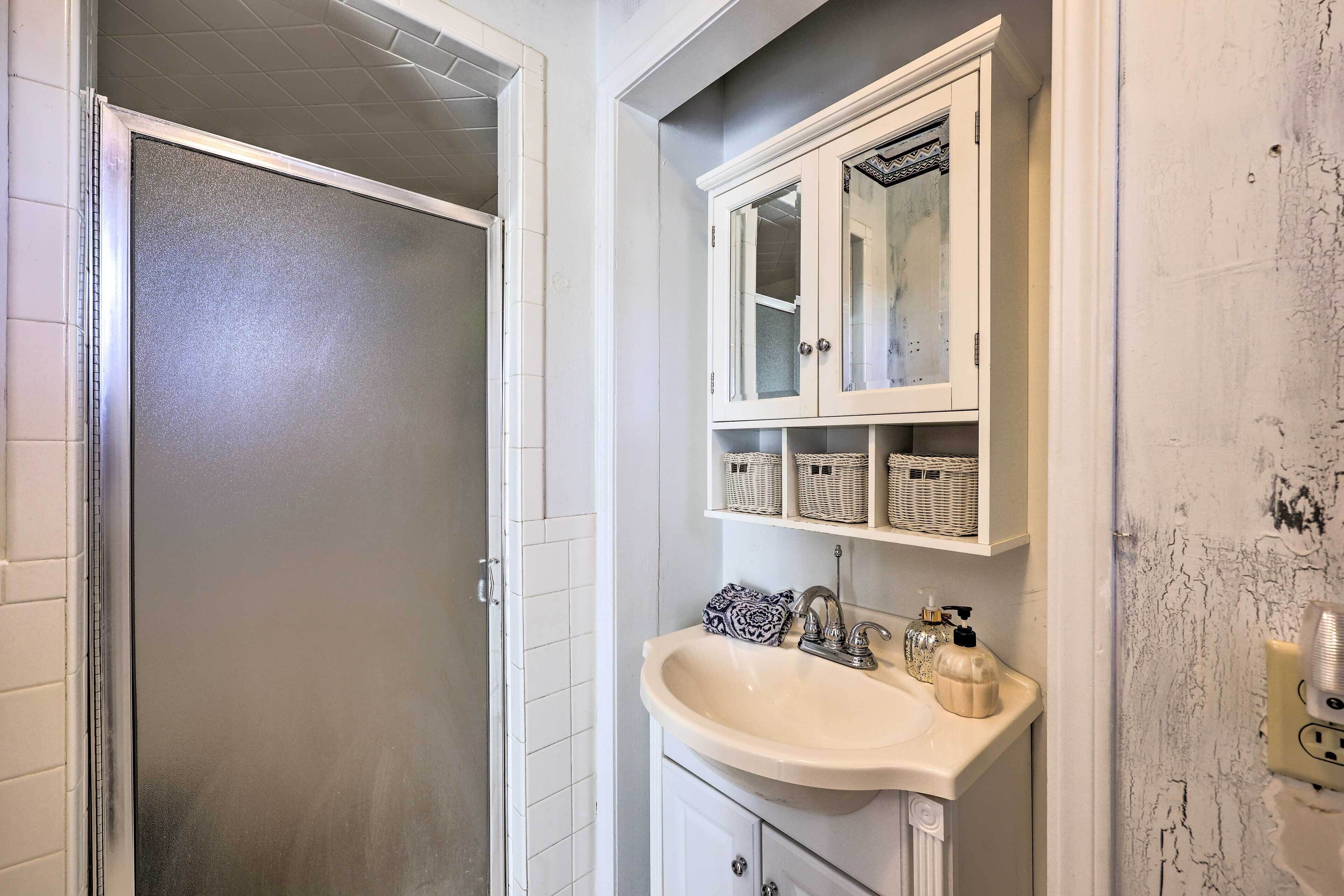 A bathroom with a white sink, a mirror, and a cabinet above it.