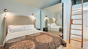 A bedroom with a bed, a large mirror, a wooden ladder, and a nightstand. - Warm & Inviting Ashland Cottage < Half-mile to SOU (Ashland)