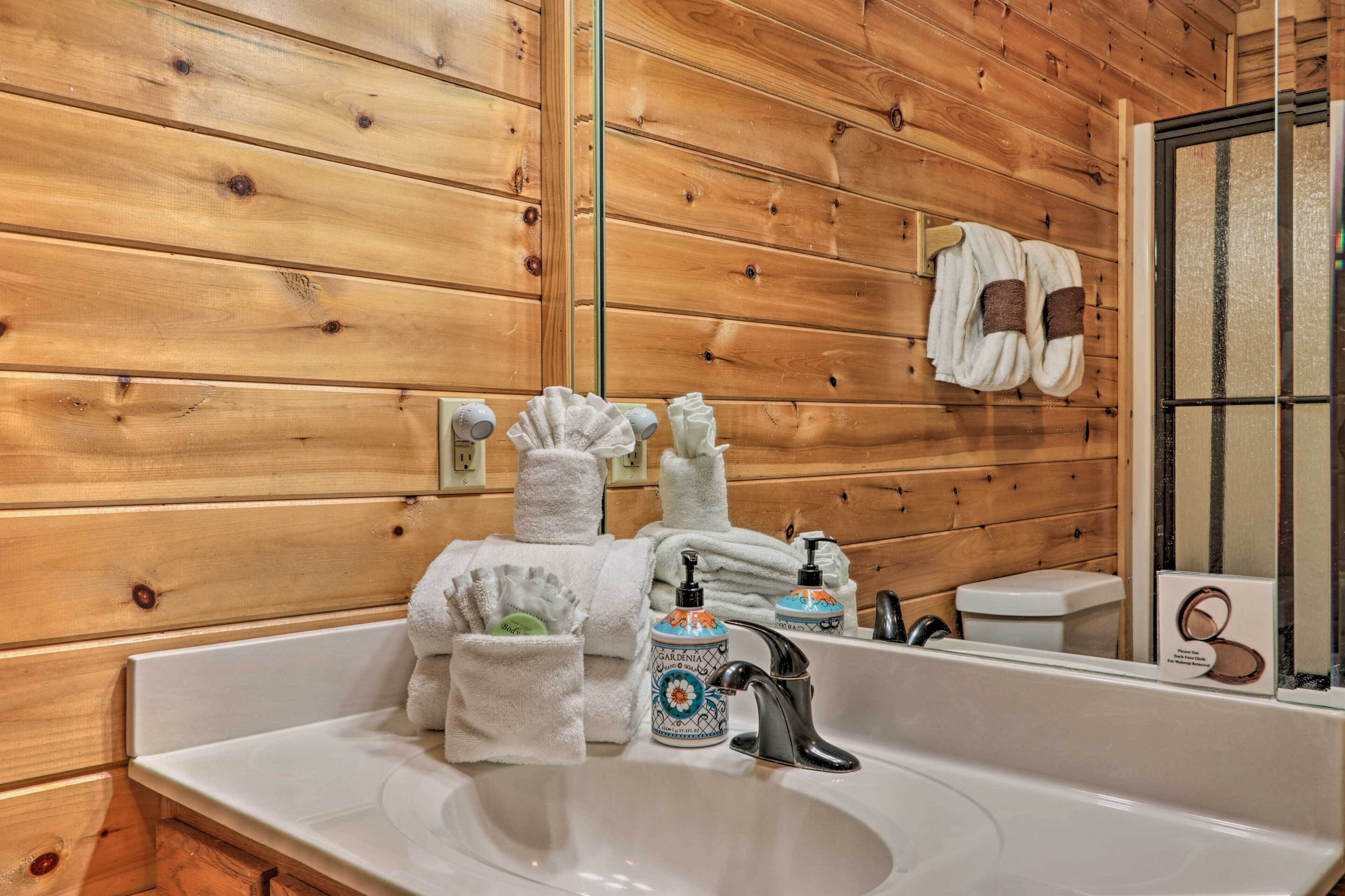 Un baño con paneles de madera, un lavamanos con grifo y artículos de aseo.