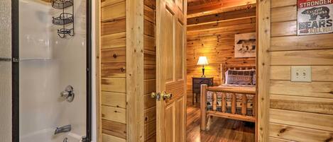 A wooden cabin interior with a shower, a bench, and a sign on the wall.