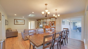 A spacious dining area with a wooden table and chairs, a chandelier, and a view of the outside through a sliding glass door. - Quiet Salinas Vacation Rental 10 Mi to Beach (Salinas)