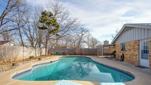 A backyard with a swimming pool, lounge chairs, and a wooden fence. - The Village Home w/ Pool, 12 Mi to Okc! (Oklahoma City)