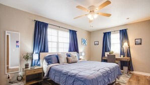 A bedroom with a bed, bedside tables, a desk, and a ceiling fan. - The Village Home w/ Pool, 12 Mi to Okc! (Oklahoma City)