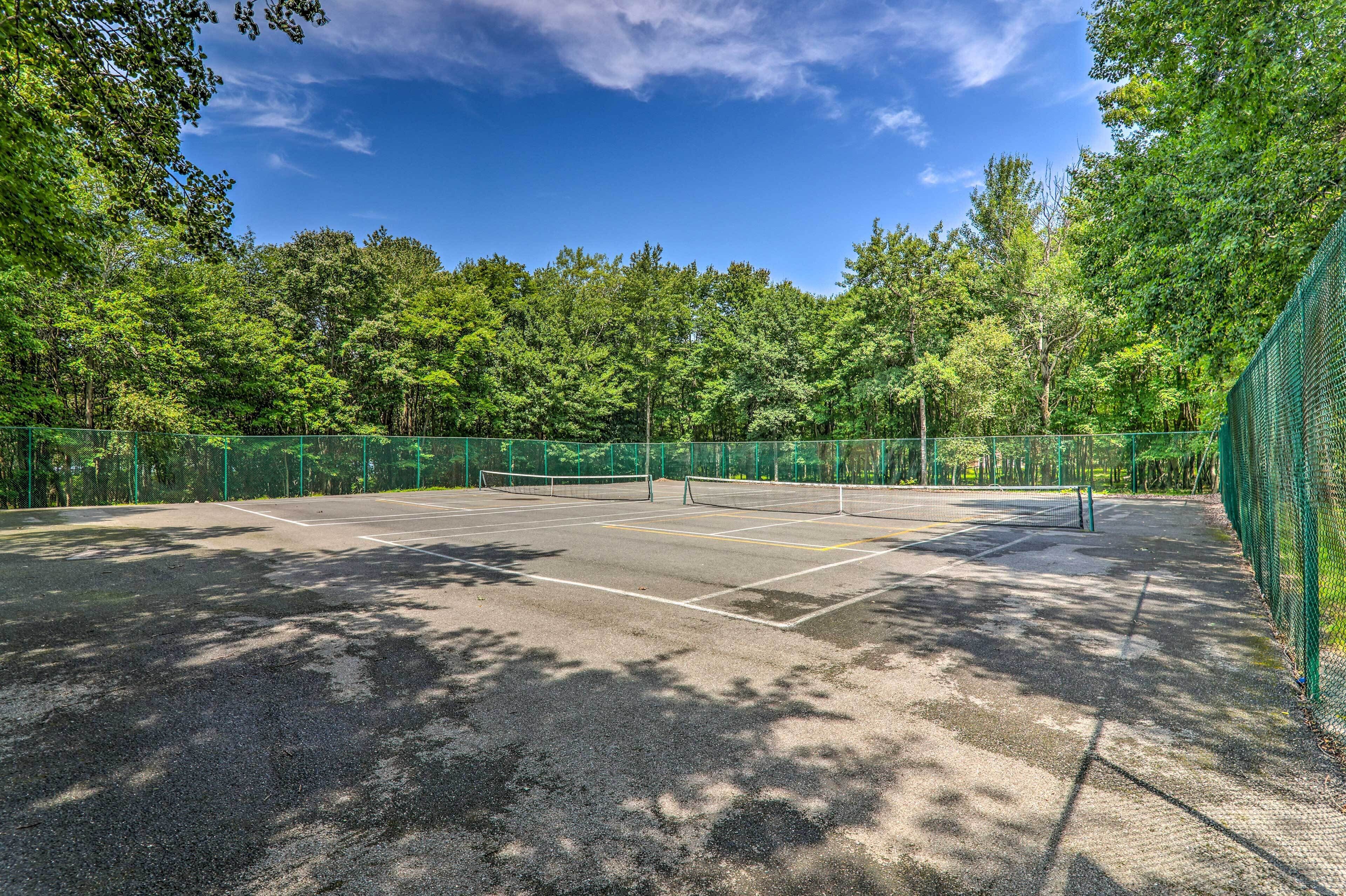 Ein Tennisplatz im Freien, umgeben von Bäumen.