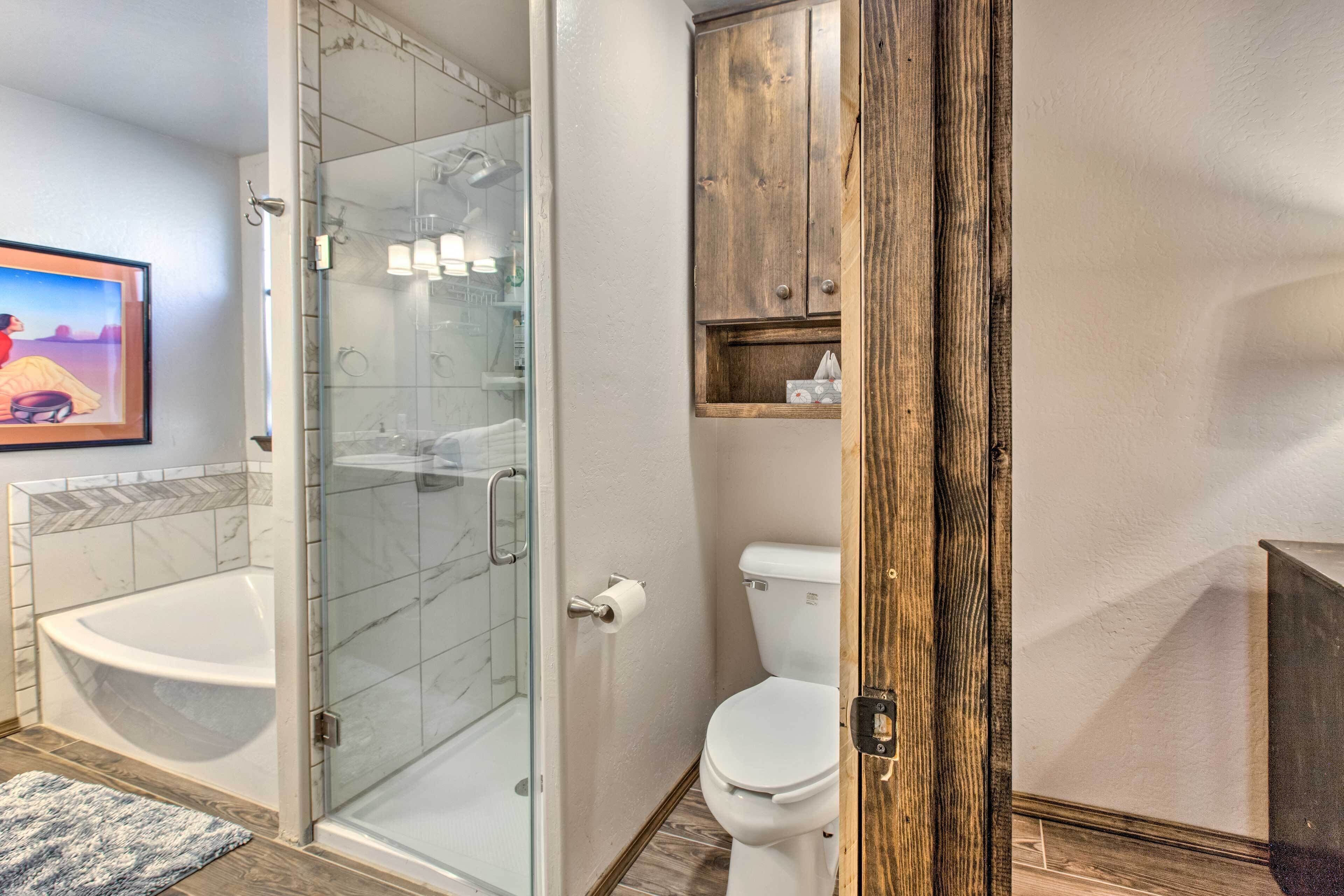A modern bathroom with a glass-enclosed shower, a white toilet, and a wooden cabinet.