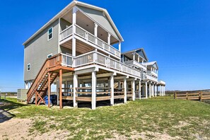 A two-story house with a balcony and a covered porch. - Gulf-view Home w/ Dog Run in Surfside Beach! (Freeport)
