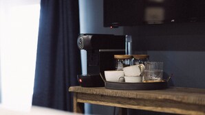 A coffee machine on a wooden table with cups and a glass. - The Silk Rooms at Freemasons Inn (Knutsford)