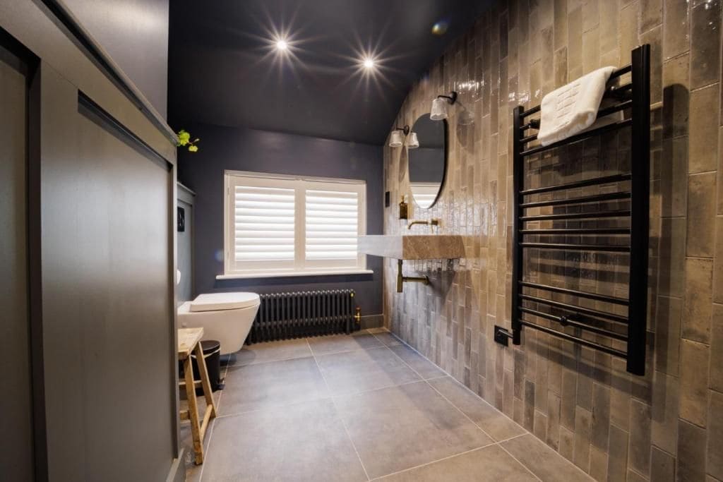 Un baño moderno con inodoro, lavamanos y toallero.