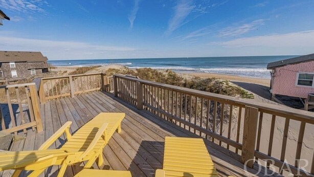 A wooden deck with yellow chairs overlooking a beach. - Amazing Beach house Steps from the Surf
"Nautical Endeavors" (Rodanthe)