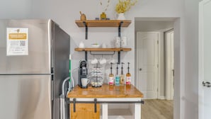 Een keuken met een roestvrijstalen koelkast, een houten aanrecht, planken met keukengerei en een bordje over reserveringen naast Stephenville.