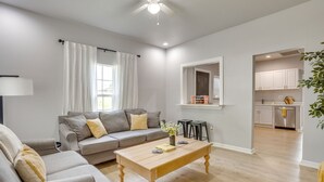 Een moderne woonkamer met een bank, salontafel en uitzicht op de keuken.