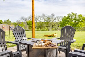An outdoor seating area with Adirondack chairs, a fire pit, and a tray with marshmallows and chocolate.
