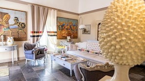 A living room with a sofa, armchairs, a coffee table, and artwork on the walls. - Jasmine Luxury House with terrace (Modica)