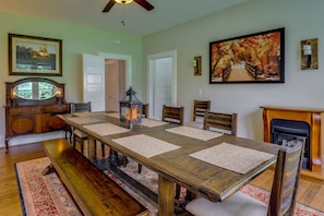 A dining room with a long wooden table, chairs, a bench, and a fireplace. - Gas Grill & Private Yard: Home in Bellville (Bellville)