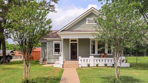 A single-story house with a front porch, a small garden, and a pathway leading to the entrance.