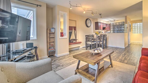 A modern living room with a flat-screen TV, a wooden coffee table, and a red couch. - Walk to Downtown & Coast Trail: Condo in Anchorage (Anchorage)