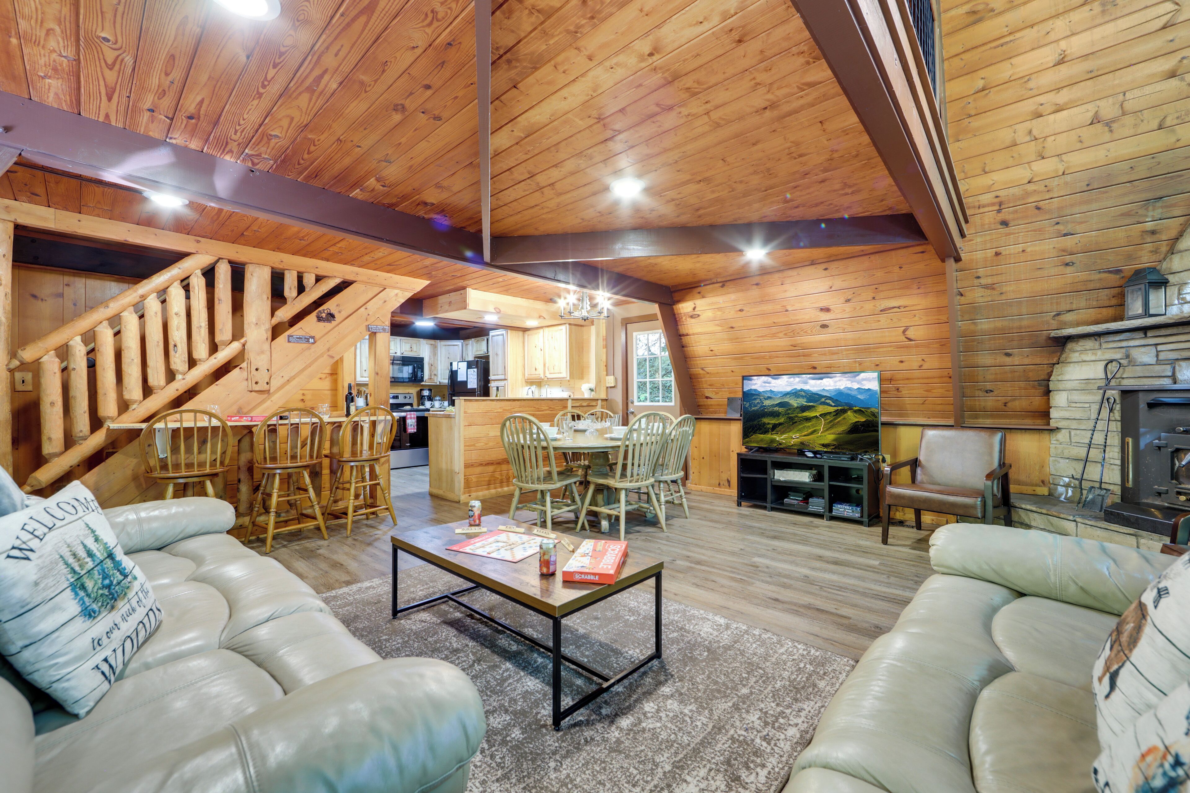A spacious living area with a wooden ceiling, a fireplace, and a dining area with wooden chairs and a table.