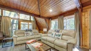 A cozy living room with two beige leather sofas, a wooden coffee table, and a small side table. - Cabin w/ Hot Tub: 2 Mi to Downtown Gatlinburg! (Gatlinburg)