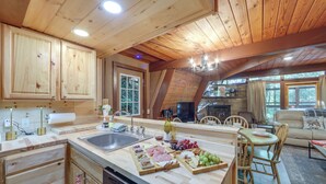 A wooden cabin interior with a kitchen, dining area, and living room. - Cabin w/ Hot Tub: 2 Mi to Downtown Gatlinburg! (Gatlinburg)